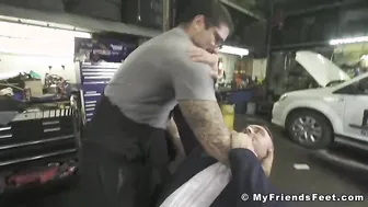 Businessman licks car mechanics feet while teasing big dick