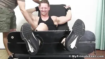 Muscular hunk laughs while having his feet and toes tickled